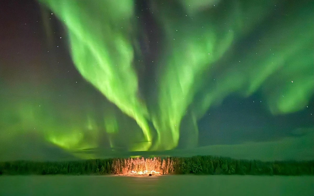 Aurora over snow-covered fells outside the village of Levi in Finnish Lapland